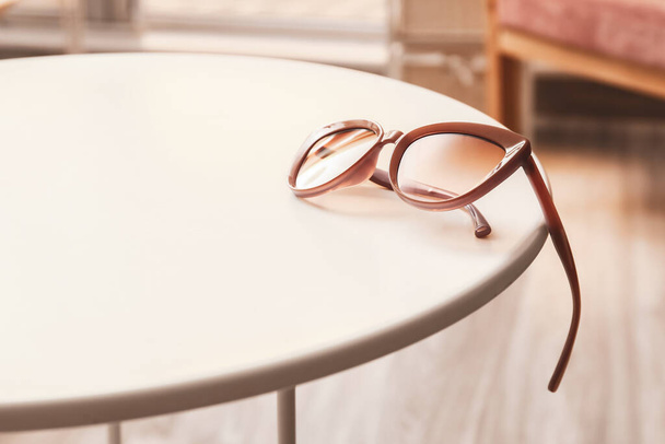 Стильные женские солнечные очки на столе - Фото, изображение