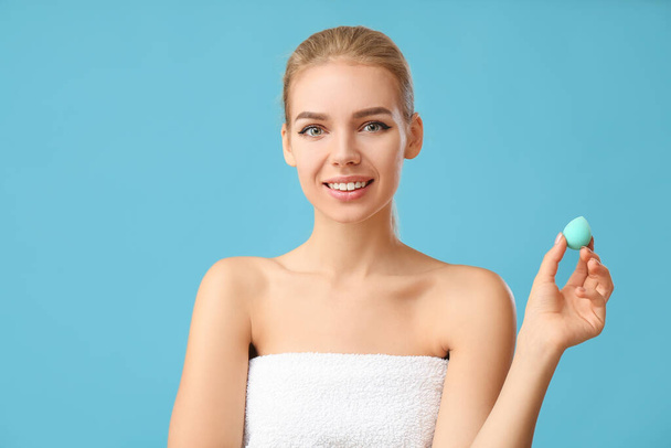 Beautiful young woman with makeup sponge on color background - Φωτογραφία, εικόνα