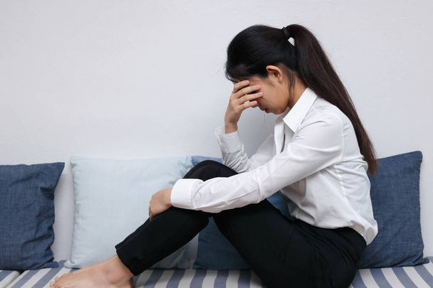 Безработная измученная молодая азиатская деловая женщина, страдающая от тяжелой депрессии в помещении. Концепция отказа и увольнения. - Фото, изображение