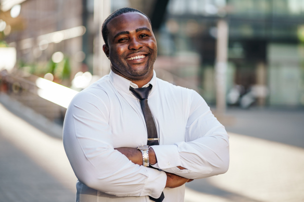 Portret van een gelukkige Afrikaans-Amerikaanse zakenman die naar de camera kijkt en glimlacht. - Foto, afbeelding