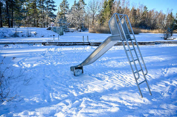 slide at a bathing place covered in snow february 2021 - Photo, Image