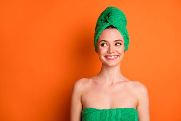 Photo of young pretty girl interested look empty space wear green towel turban isolated orange color background - Φωτογραφία, εικόνα
