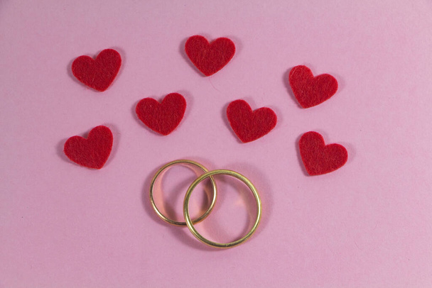 Two wedding rings and pink hearts for Valentine's day - Фото, зображення