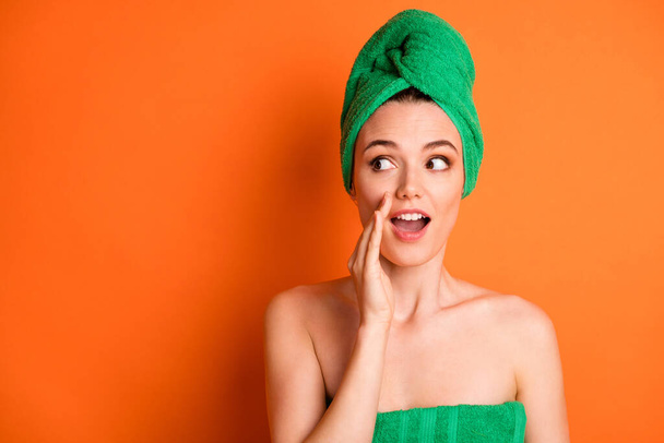 Photo of young lovely lady arm open mouth look empty space wear green towel turban isolated orange color background - Photo, image