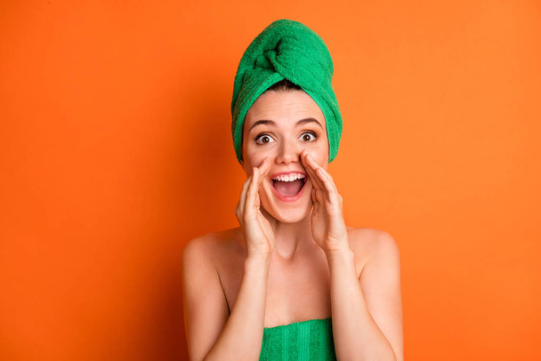 Photo of young pretty excited girl palms open mouth look camera wear green towel turban isolated orange color background - Foto, Bild