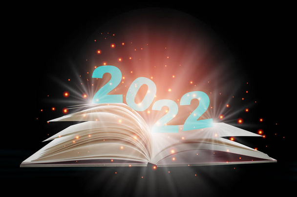 New year 2022 on open white paper fantasy book with shining pages isolated on black background. Miracle happiness holiday concept and mystery beginning idea - Photo, Image