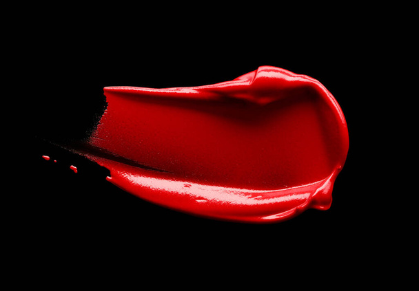 Rode lippenstift beroerte geïsoleerd op zwarte achtergrond - Foto, afbeelding