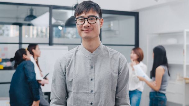 Portrait of successful handsome executive businessman smart casual wear looking at camera and smiling, happy in modern office workplace. Young Asia guy standing relax in contemporary meeting room. - Photo, Image
