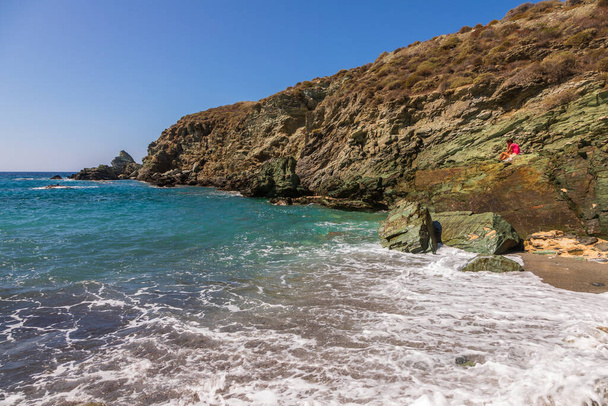 Folegandros Island, Grecia - 25 settembre 2020: Veduta della costa e della spiaggia rocciosa di Ampeli dell'isola di Folegandros. La gente sta prendendo il sole sulla spiaggia. Mar Egeo, Arcipelago delle Cicladi. - Foto, immagini