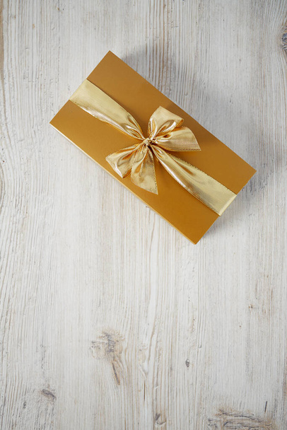 golden box of chocolate on wooden white surface - Φωτογραφία, εικόνα