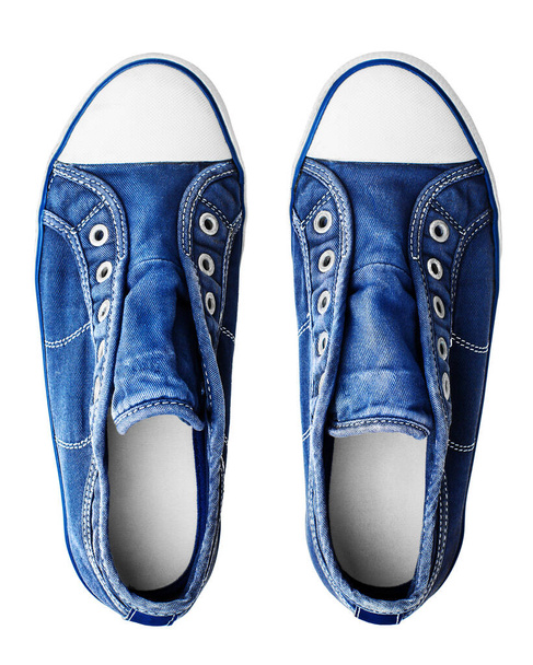 Zapatillas azules fondo blanco aislado vista superior, elegantes zapatos de goma sin cordones, par de zapatos de mezclilla deportiva, dos botas de tela casuales, calzado textil para caminar de moda, calzado de lona - Foto, imagen