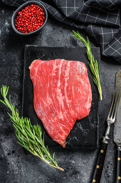 平らな鉄ステーキ。生の大理石の牛肉肉黒アンガス.黒の背景。トップ表示 - 写真・画像
