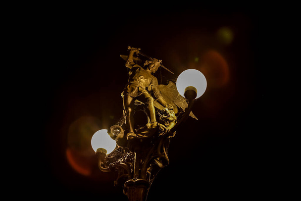 κατά τη διάρκεια της νύχτας το όμορφο κεντρικό φανάρι με το χάλκινο άγαλμα του Αγίου Μιχαήλ λάμπει - Φωτογραφία, εικόνα