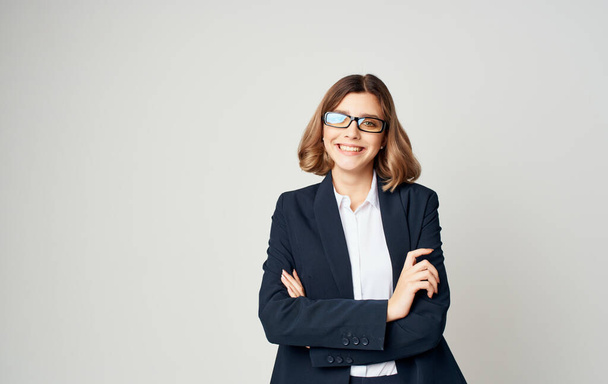 Portrait of a business woman in a classic suit and glasses on a light background cropped view - Фото, зображення