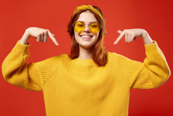 χαρούμενη συναισθηματική γυναίκα με γυαλιά κίτρινο πουλόβερ close-up κόκκινο φόντο - Φωτογραφία, εικόνα