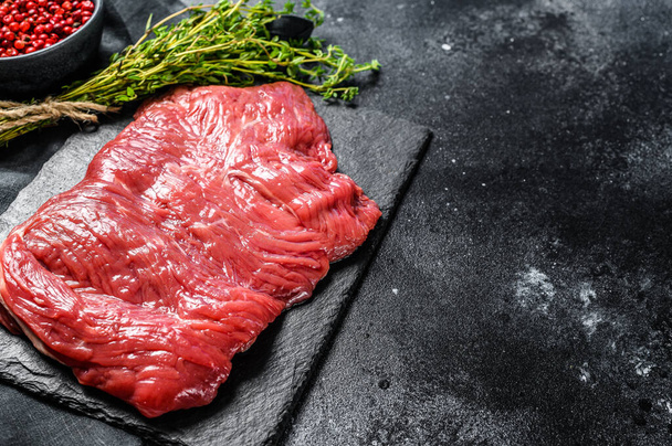 Raw flank steak, marbled meat. Black background. Top view. Copy space - Foto, imagen