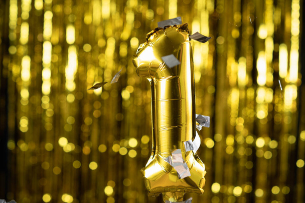 Χρυσό αλουμινόχαρτο νούμερο 1 ένα εορταστικό μπαλόνι σε κίτρινο φόντο. Η έννοια των γενεθλίων, επέτειο, - Φωτογραφία, εικόνα