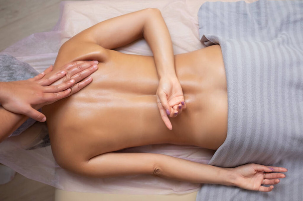 Femme caucasienne obtenir un massage de la colonne vertébrale dans le salon de spa - Photo, image