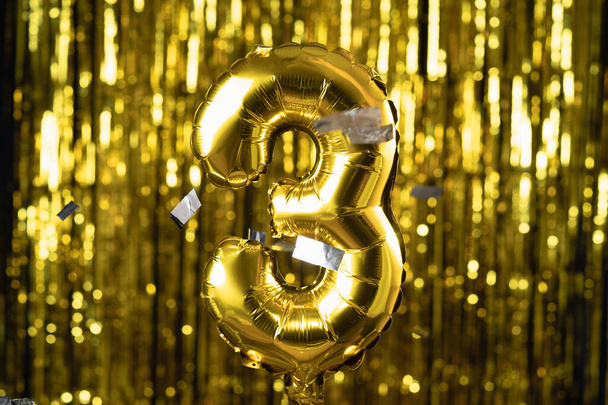 Gold foil number 3 three festive balloon on a yellow background. The concept of birthday, anniversary, - Zdjęcie, obraz