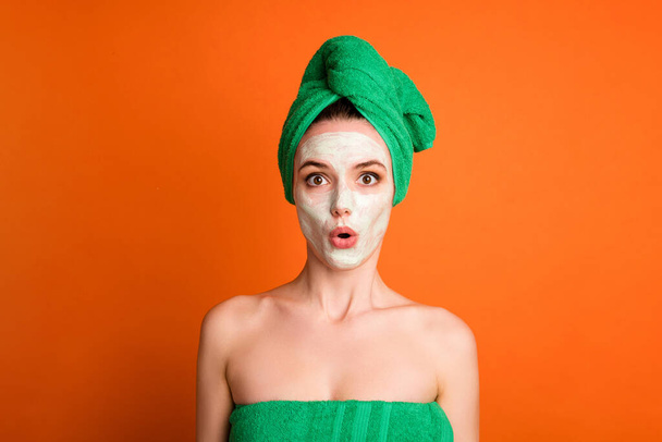 Photo surprised funny lady wear green towel head mask face isolated orange color background - Fotografie, Obrázek