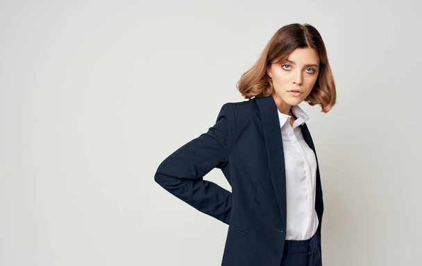 Mulher de negócios em um terno em um fundo cinza segura uma mão na cintura Espaço Copiar - Foto, Imagem