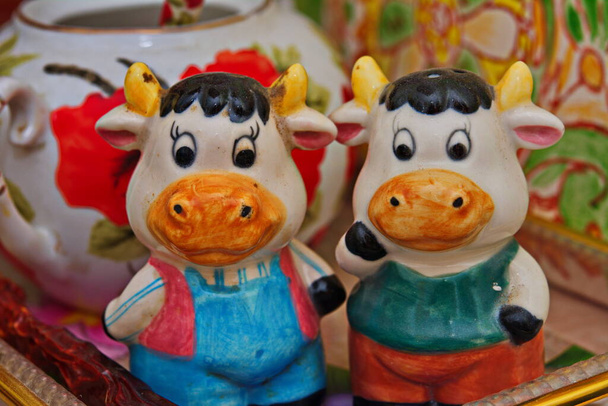 牛や牛の装飾的な人形。角や足を持つ牛のガラスの図。贈り物とかわいい黒と白の牛の図 - 写真・画像