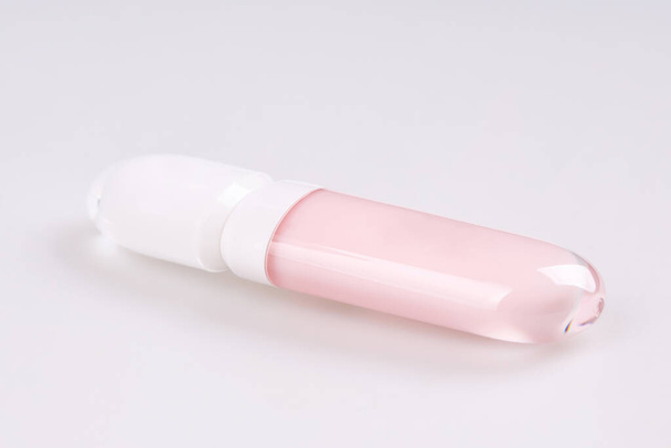 Tubo de brillo de lápiz labial líquido con aplicador aislado sobre fondo blanco - Foto, imagen