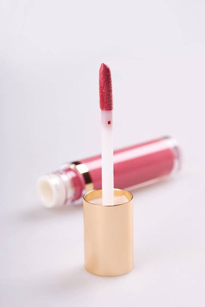 Tubo de brillo de lápiz labial líquido con aplicador aislado sobre fondo blanco - Foto, Imagen