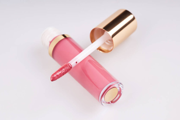 Tube de rouge à lèvres liquide brillant avec applicateur isolé sur fond blanc - Photo, image
