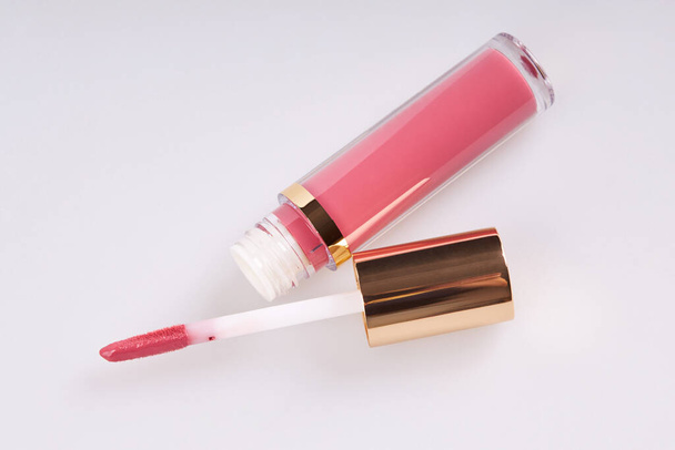 Tubo de brillo de lápiz labial líquido con aplicador aislado sobre fondo blanco - Foto, imagen