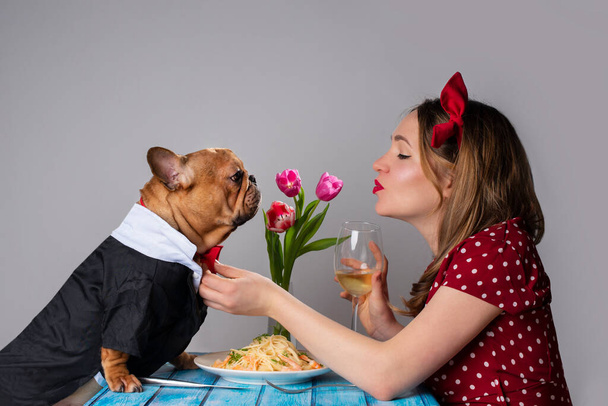 νεαρή κοπέλα στο ρομαντικό ραντεβού του Αγίου Βαλεντίνου με το σκύλο της γαλλικό μπουλντόγκ - Φωτογραφία, εικόνα
