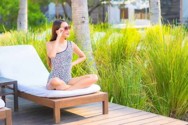 Retrato hermosa joven asiática mujer relajarse sonrisa disfrutar de ocio alrededor de la piscina en resort hotel de vacaciones - Foto, imagen