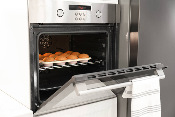 Baking pan with cupcakes in modern oven - Foto, immagini