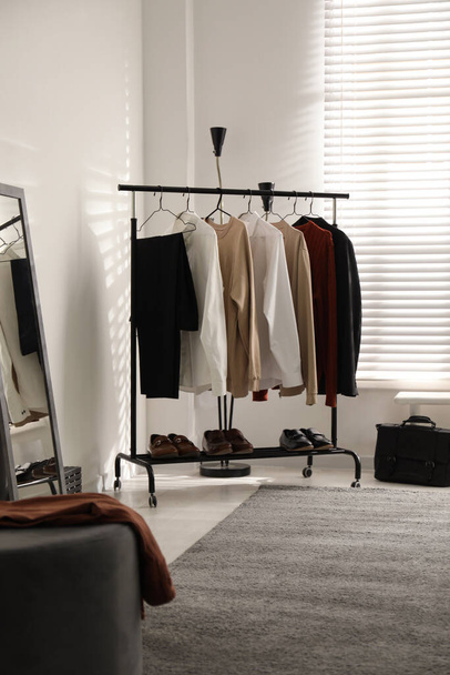 Rack with stylish men's clothes indoors. Interior design - Φωτογραφία, εικόνα