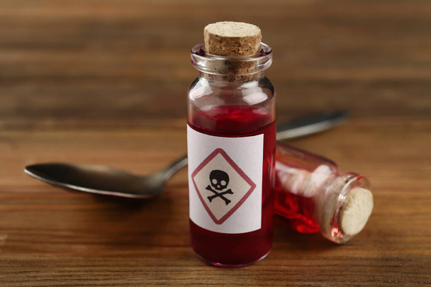 Vials of poison with spoon on wooden table, closeup - Photo, Image