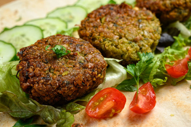 Homemade falafel on pita bread with tomatoes, cucumber and lettuce  - Fotó, kép
