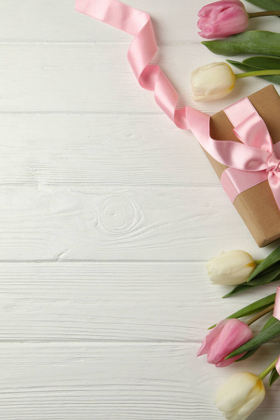 Beautiful tulips and gift box on white wooden background - Photo, Image