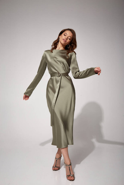 Beauty brunette woman luxury lifestyle bright makeup wear natural organic silk midi dress high heels perfect body shape fashion model style for meeting party or romantic date studio grey background. - 写真・画像