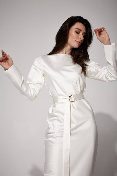 Sexy brunette woman luxury lifestyle bright makeup wear natural organic white silk midi dress wedding bride high heels perfect body shape fashion model style for meeting party romantic date studio. - 写真・画像