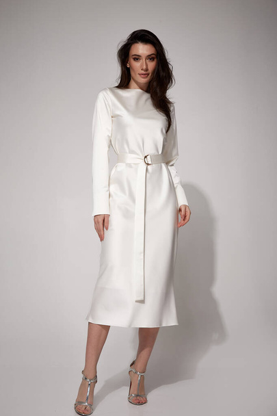 Sexy brunette woman luxury lifestyle bright makeup wear natural organic white silk midi dress wedding bride high heels perfect body shape fashion model style for meeting party romantic date studio. - 写真・画像