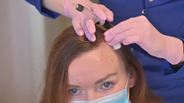 Kosmetyk wykonuje zastrzyki witamin i minerałów w skórę głowy kobiet, aby zapobiec lub spowolnić wypadanie włosów - Materiał filmowy, wideo