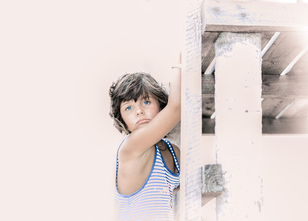 isolated portrait of little girl holding wooden pier - 写真・画像