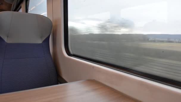 Pohled na interiér v opuštěném prázdném vagónu s řadami sedadel a stolů projíždějících venkovskou krajinou - Záběry, video