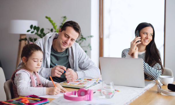 Parents with school girl indoors at home, distance learning and home office. - Foto, immagini