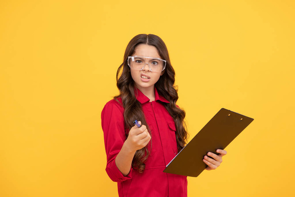 unexpected result. work with documents. surprised kid in protective glasses. childhood. teen girl wear eyeglasses. kid make notes in folder on yellow background. child study at school. - Photo, Image