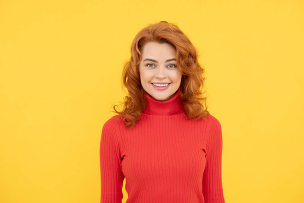 Portret pięknej rudej dziewczyny kręcone włosy uśmiechnięty śmiech patrząc w kamerę na żółtym tle - Zdjęcie, obraz