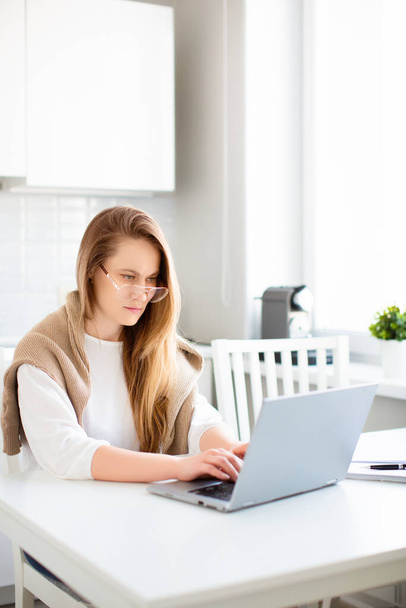 Робота вдома онлайн. Фото жінки перед мотором ноутбука в домашньому інтер'єрі
. - Фото, зображення