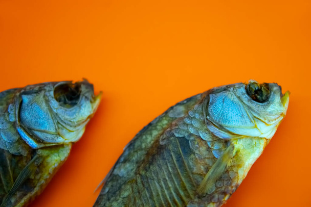 Sucha ryba na pomarańczowym tle, zbliżenie - Zdjęcie, obraz
