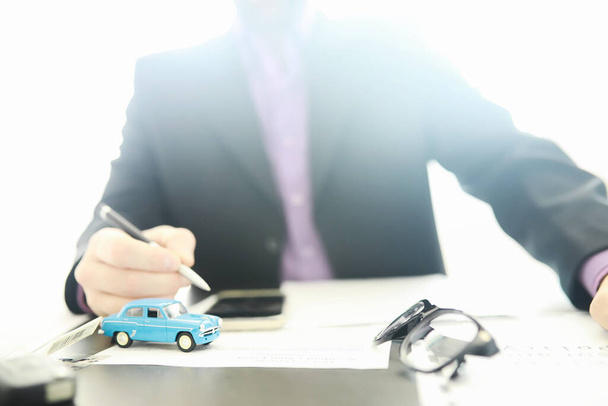 L'agente di assicurazione firma un documento. Assicurazione auto. Assicurazione auto. Moduli di registrazione del contratto. - Foto, immagini