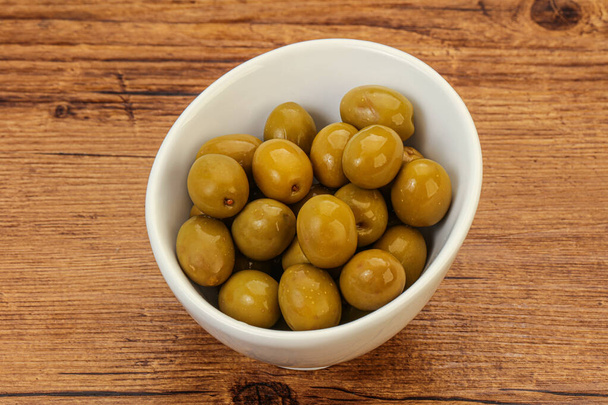 Green pickled olives heap in the bowl - Foto, afbeelding